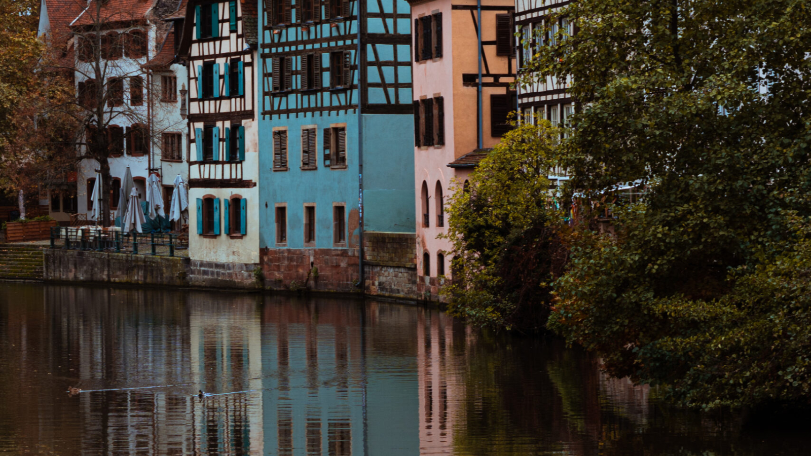 A vertical shot of vintage small houses along the river in the Petite-France region of Strasbourg